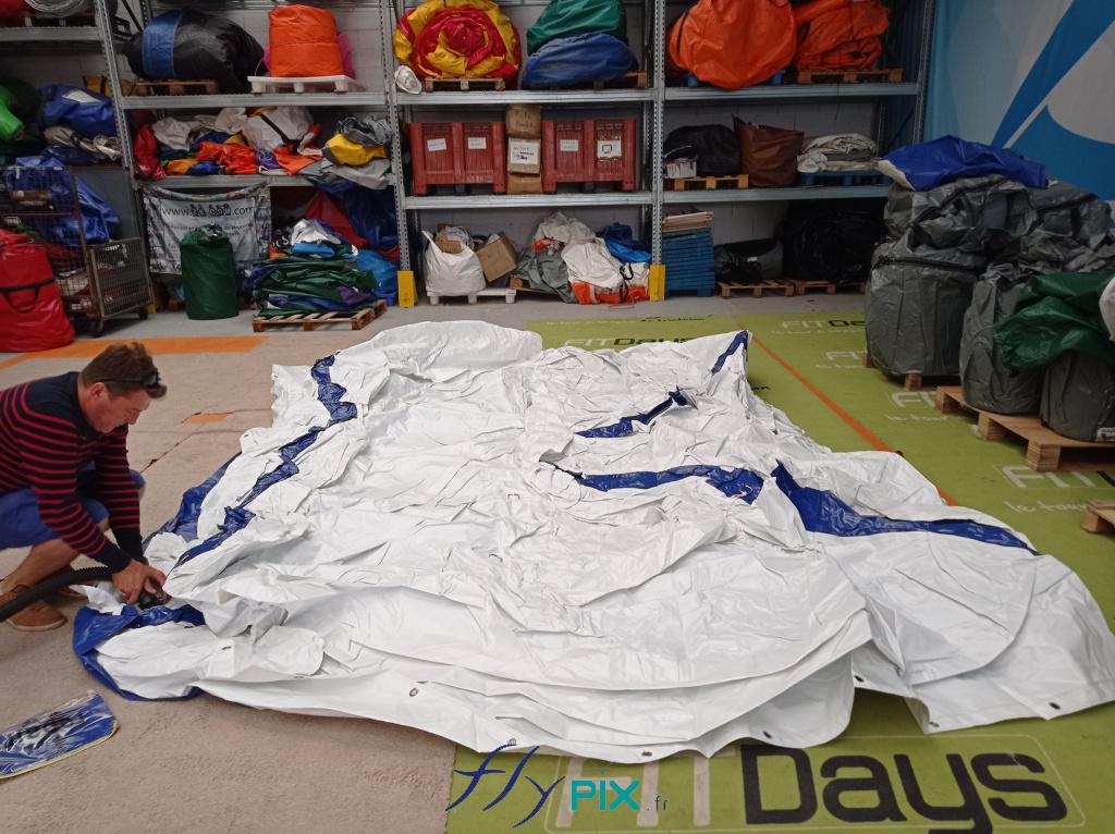 La tente PMA 4 x 3 m de Etienne Lacroix, de couleur blanche et bleue, air captif, dégonflée pour le pliage et le rangement dans son sac.